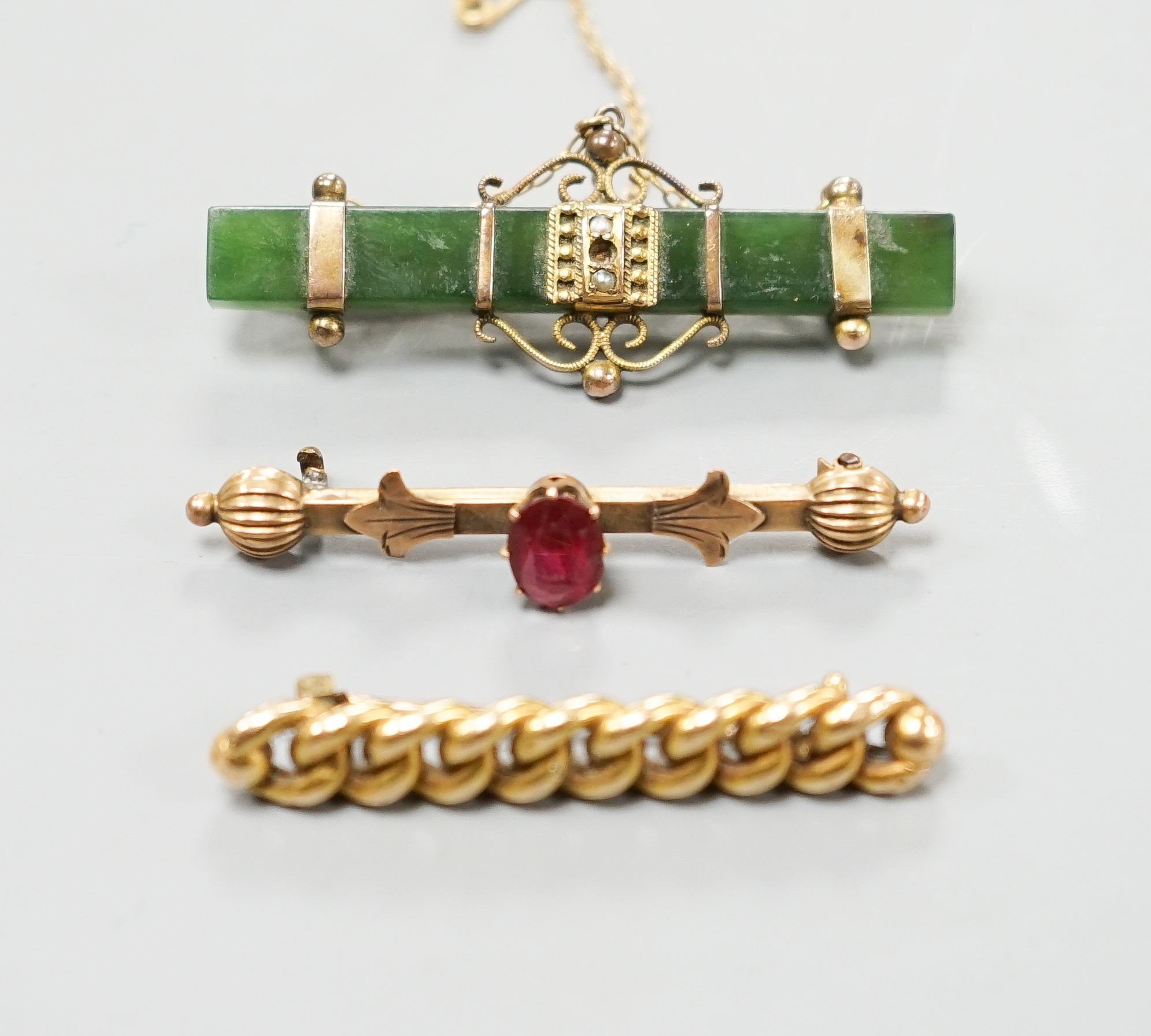 An Edwardian 15ct interwoven bar brooch, 45mm gross 4.2 grams, a mounted nephrite bar brooch and one other bar brooch.